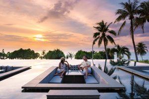 couple watching sunset in infinity pool on a luxury vacation in Thailand