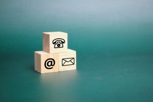 three wooden cubes with contact icons.